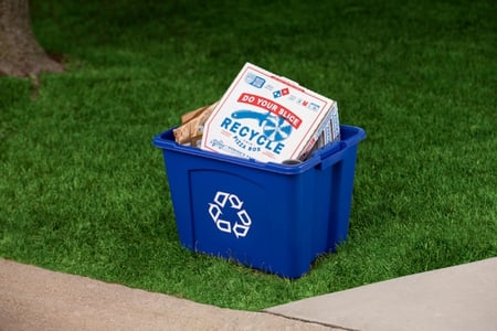 Domino's pizza box in a blue recycling bin.
