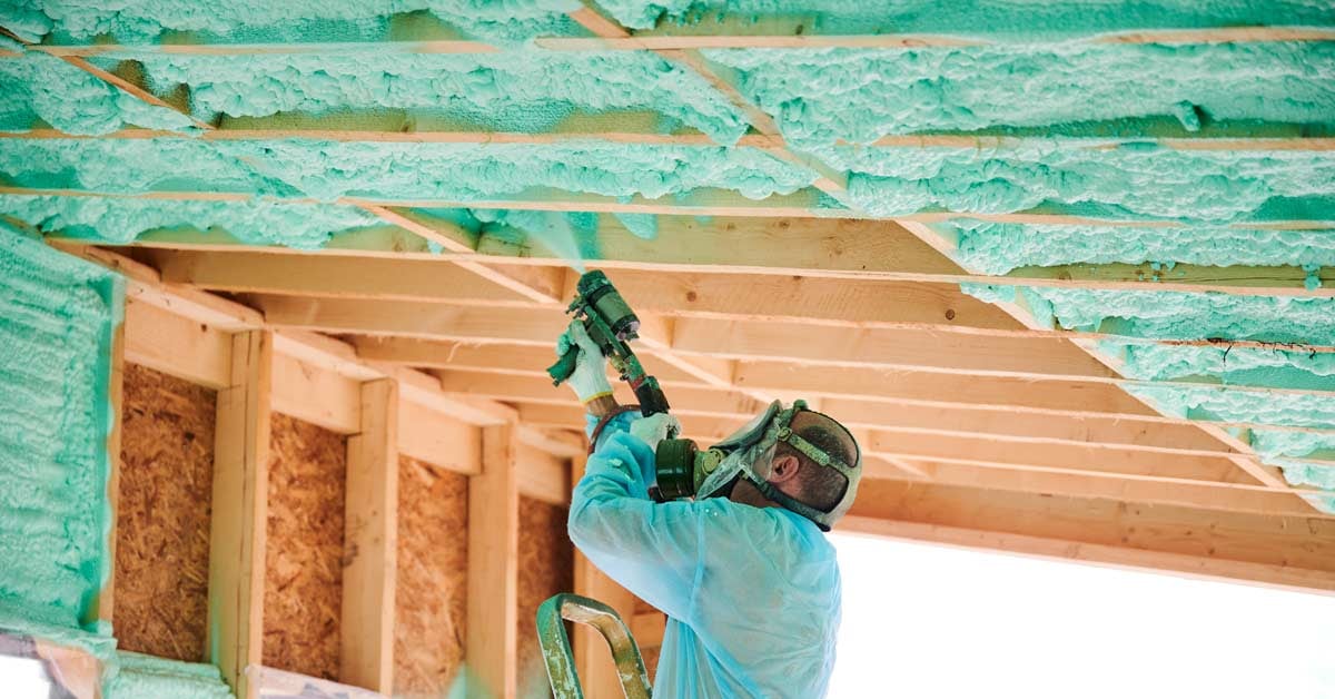Polyurethane foam being applied to a building frame for insulation.
