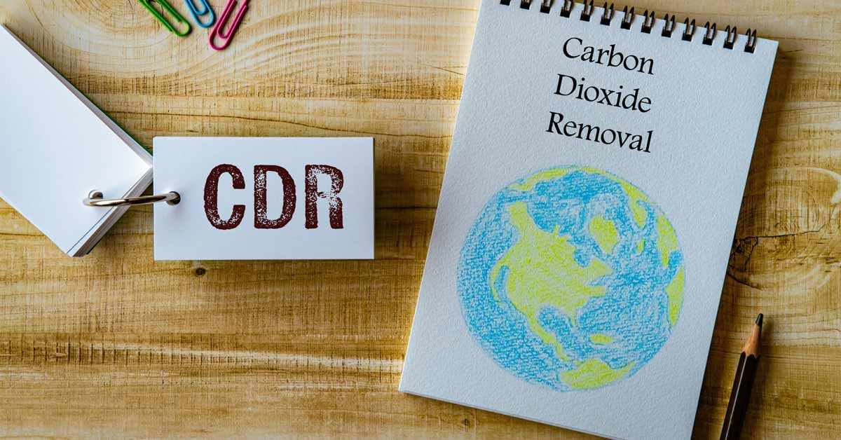 Two note pads, one with a drawn globe and the words carbon dioxide removal and the other with CDR written.
