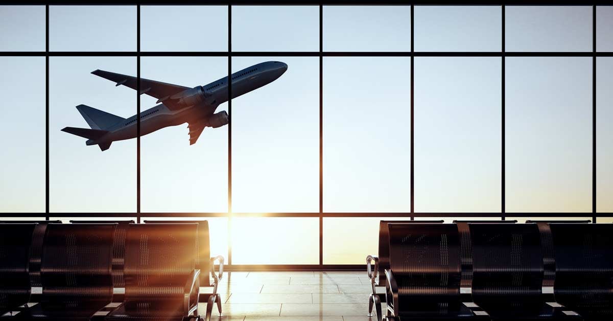 View of an airplane ascending in liftoff from the windows of an international airport.