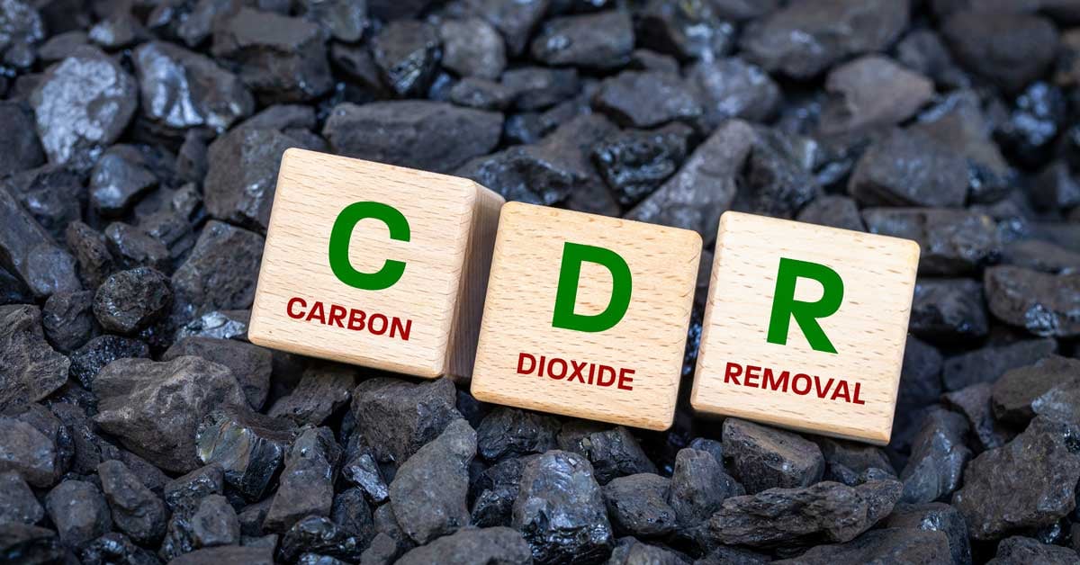 Wood blocks on a pile of biochar that say CDR, carbon dioxide removal.