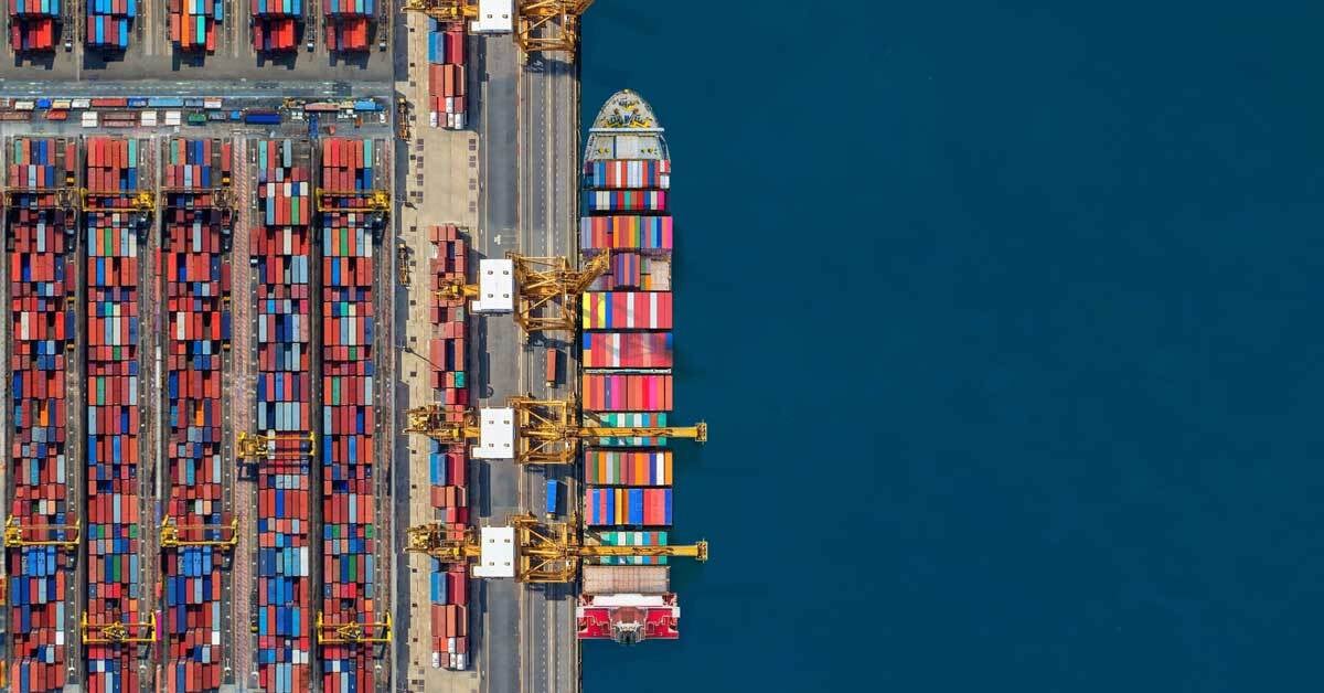 A shipping vessel at a bustling shipping port.