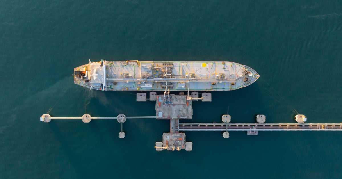 An oil tanker loading and unloading fuel at a port.
