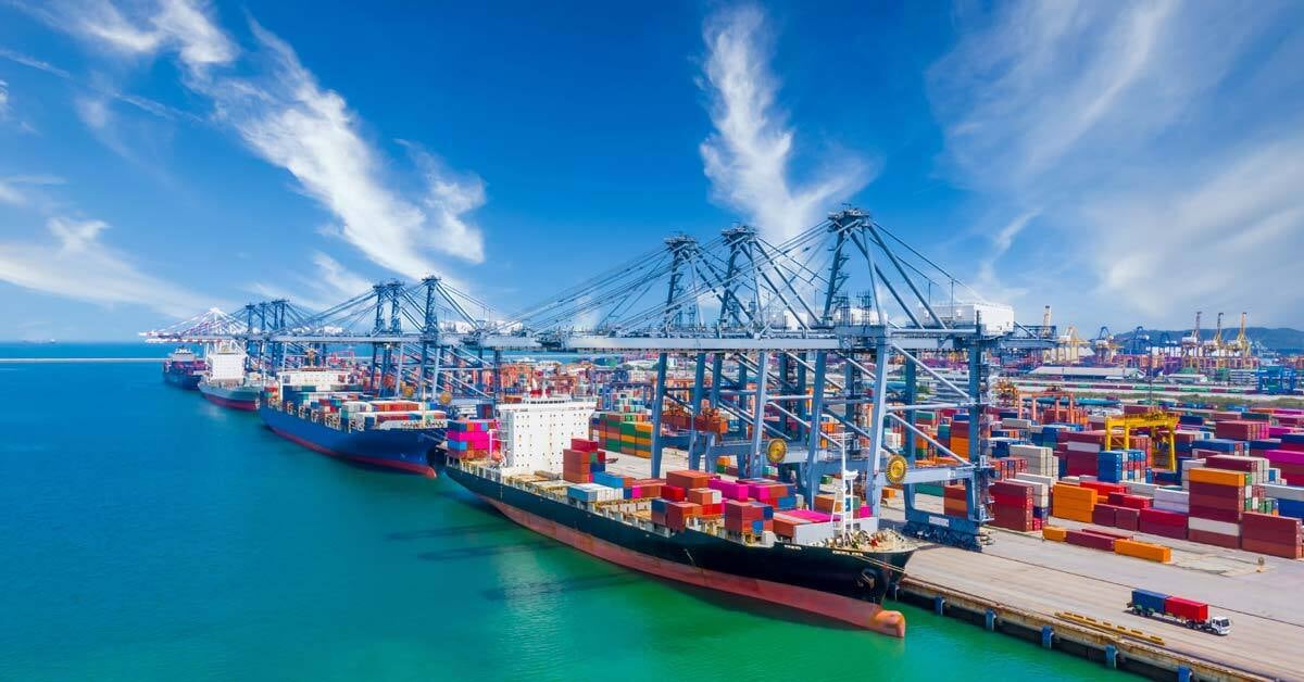 Several ships docked at a bustling commercial shipping port.