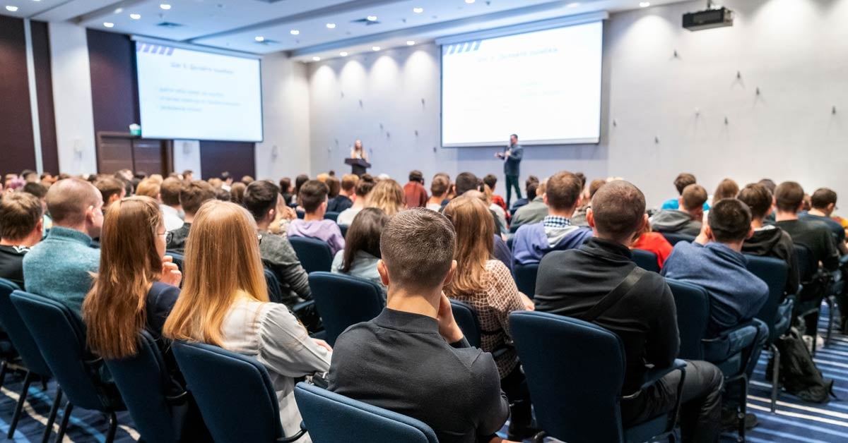Audience in a conference room watching a presentation.