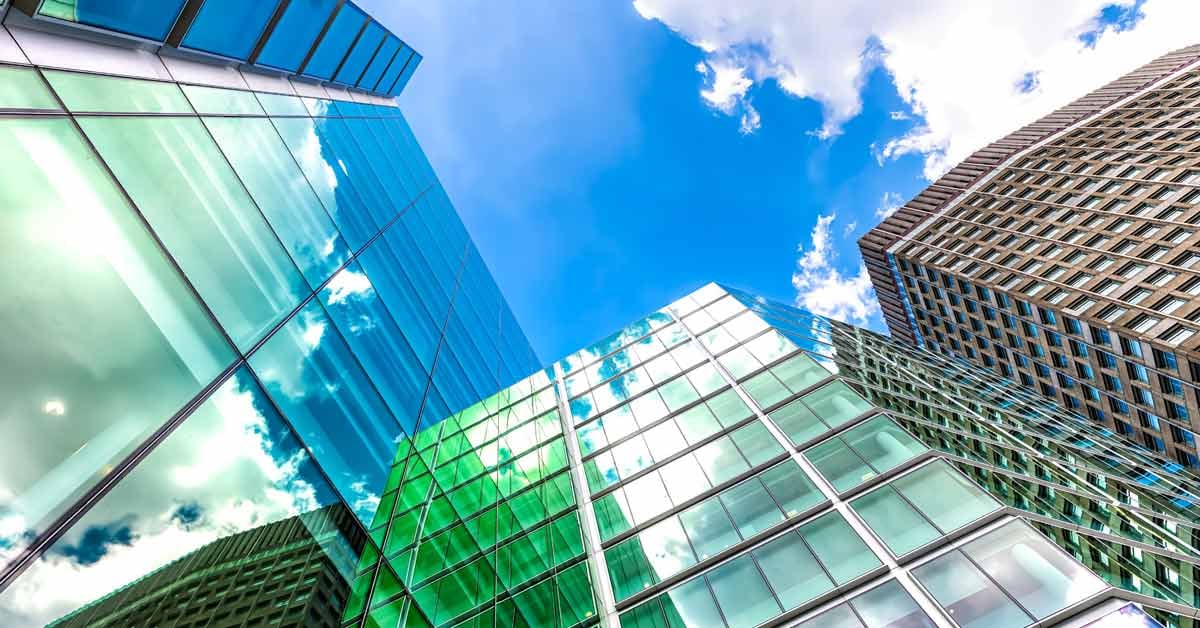 Upward view of a corporate headquarters with green accents to symbolize sustainability.