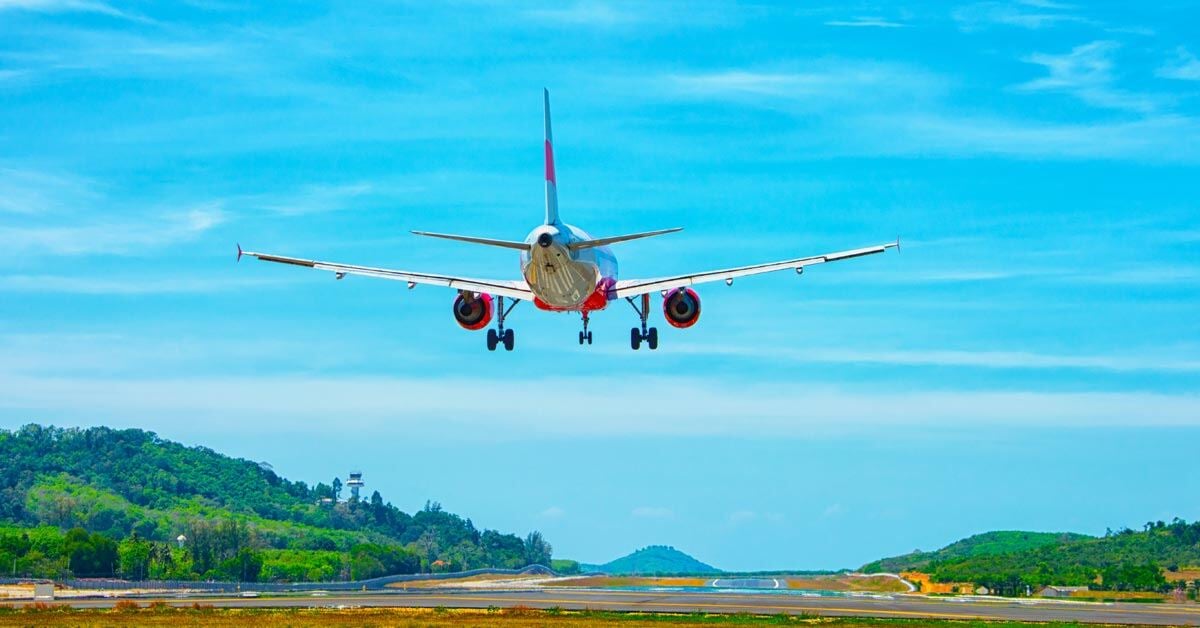 A commercial airplane landing at an airport in Southeast Asia.
