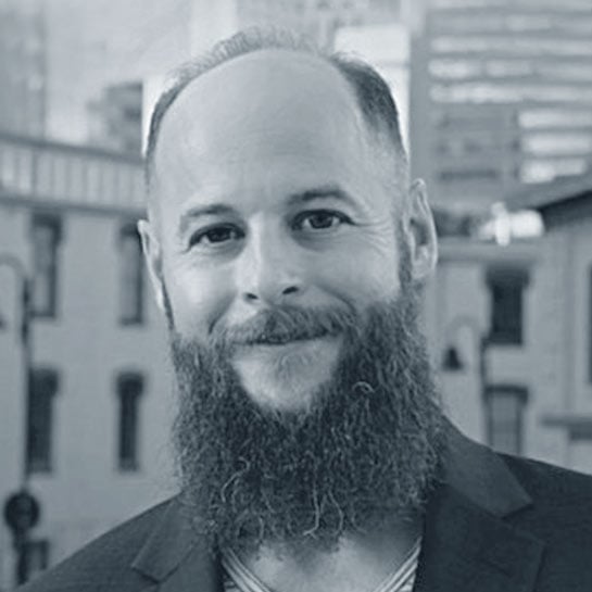 Headshot of Justin Barnes in black and white. 