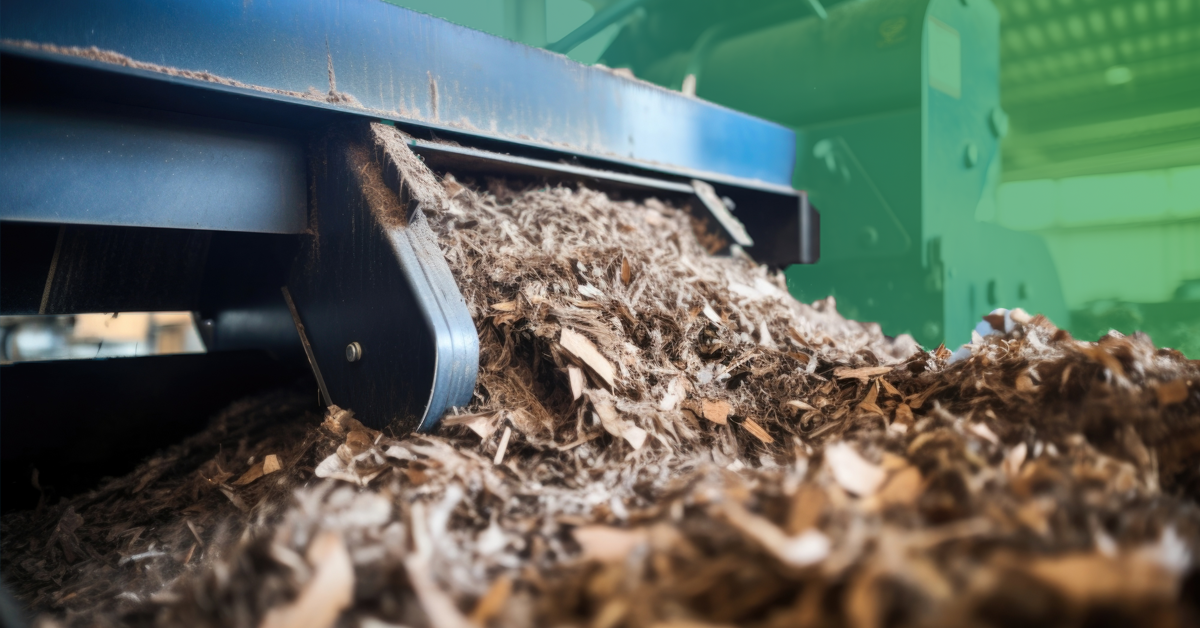 Closeup of a massive shredder machine through waste agricultural materials, breaking them down into smaller, uniform pieces before further processing.