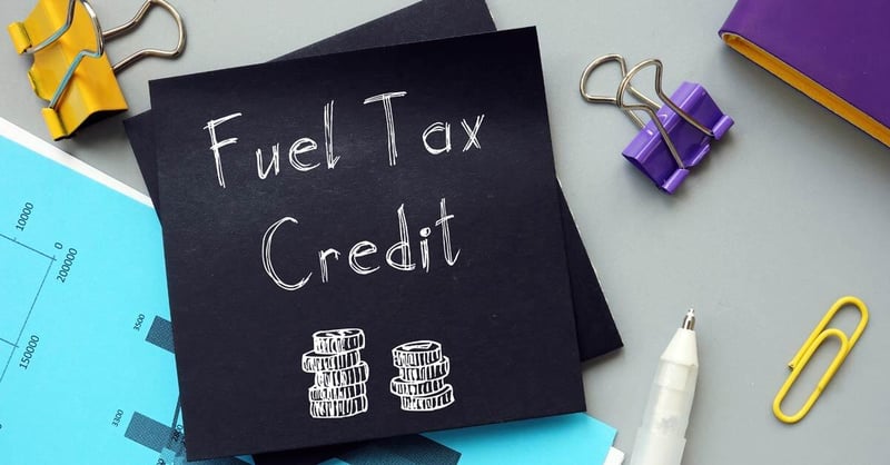 A desk with papers, clips, and a pen and a paper that says "Fuel Tax Credit" for the IRS 45Z Clean Fuel Tax Credit.