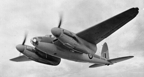 The allied bomber flies in the sky in a black and white photograph. The Mosquito airplane  bomber was dubbed the wooden wonder.