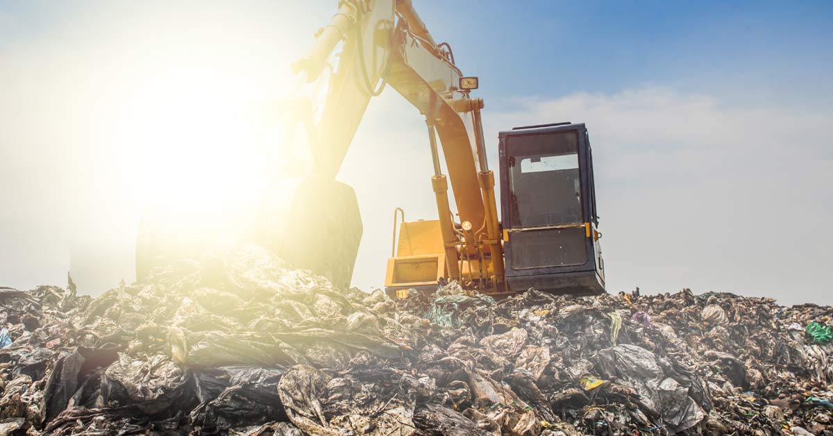A municipal waste dump with various machines processing and sorting.