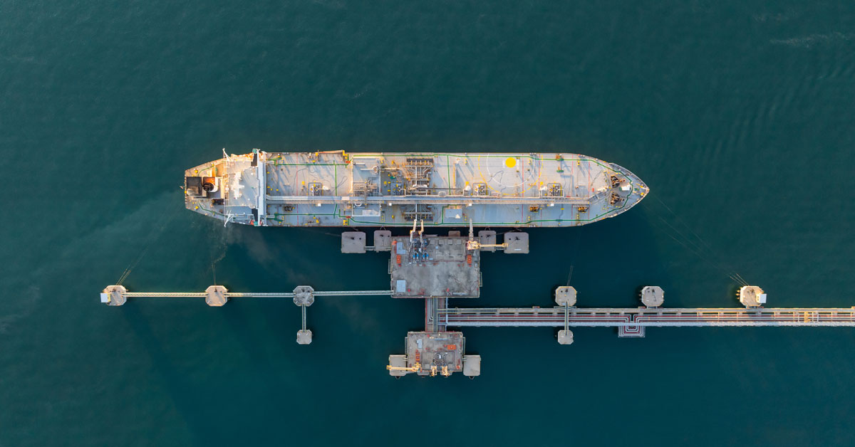 An oil tanker loading and unloading fuel at a port.