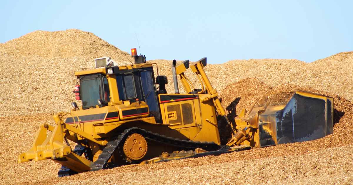An earthmover pushes a pile of wood chips bound for Pacific rim countries like China and Japan.